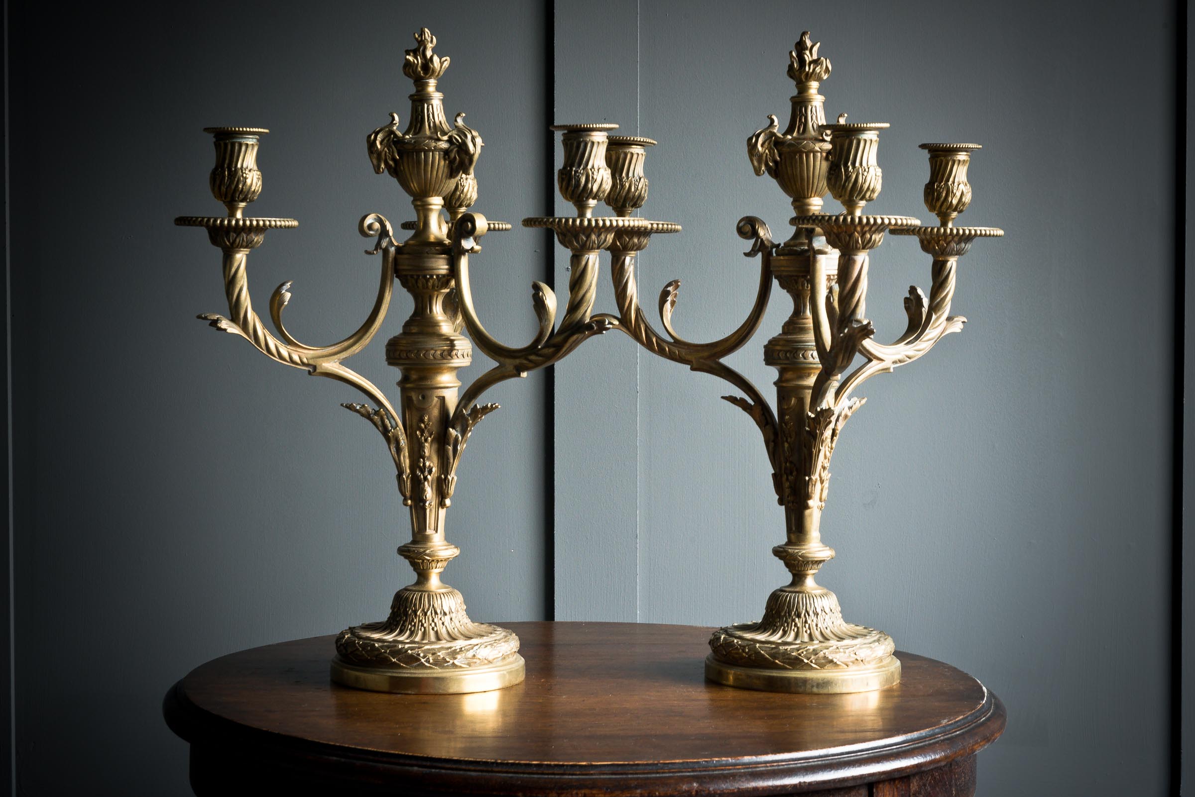Stunning twin pair of french brass candelabra each consisting of three scrolled arms on a shallow dome base.