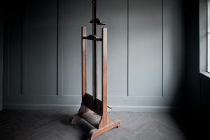Late 19th century artist easel made from dark oak complete with a crank mechanism set on four small wheels