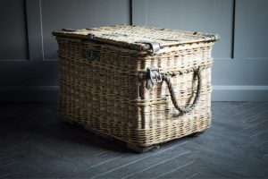 Cravens Laundry Basket made from wicker with thick rope handles on either end finished with leather straps and clasp for fastening.
