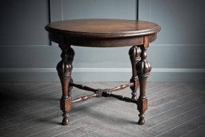 A beautiful solid turned oak side table with a round table top and four beautifully ornate legs that intersect. ⁠