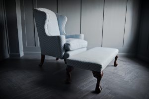 A stunning pale blue, scallop pattern Queen Anne winged back chair with beautiful dark wood claw and ball front feet. Comes with a matching long stool.