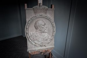Bronze fountain plaque depicting Edward VII portrait dressed in finery in low relief