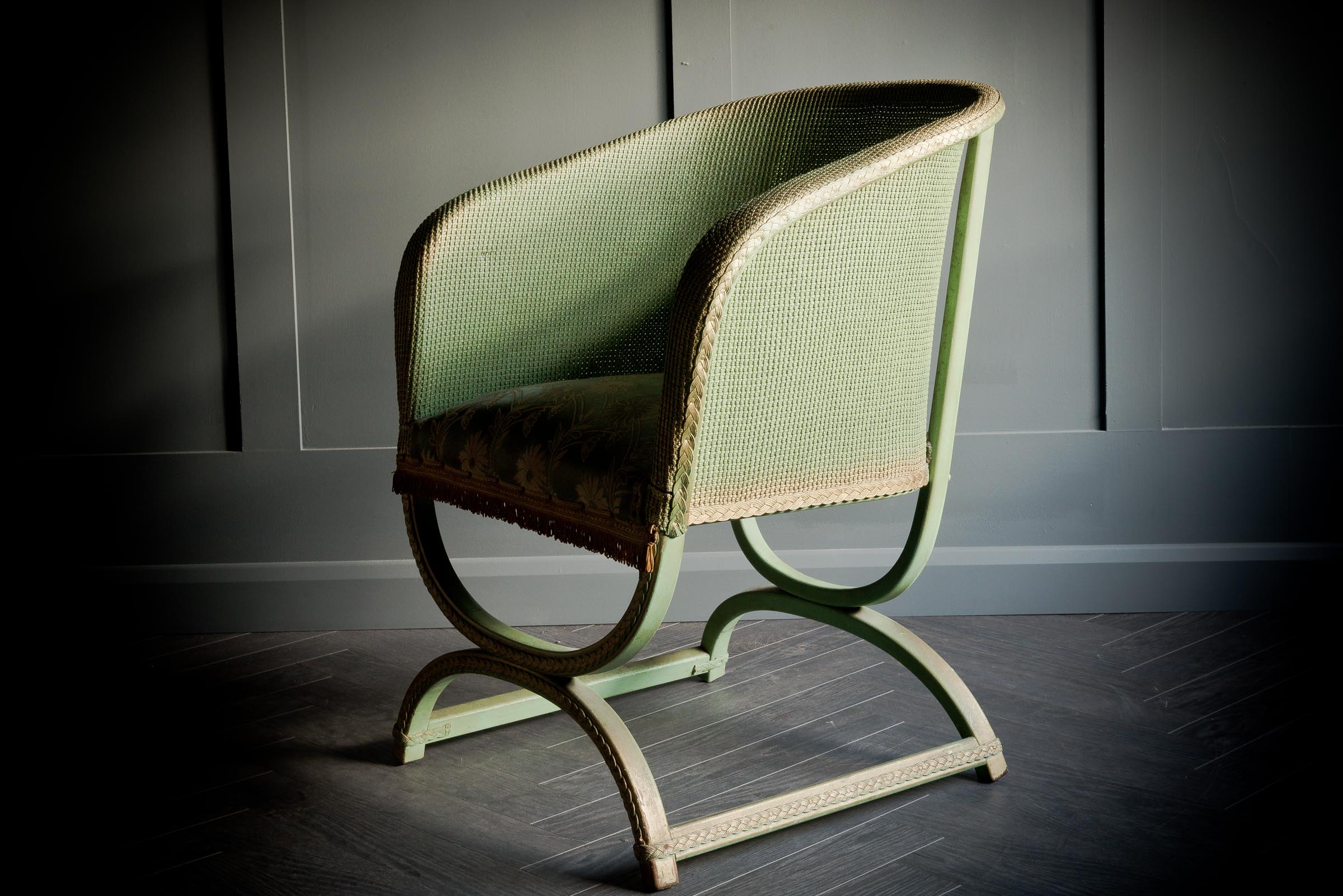 Lloyd Loom Sarvonola style chair in woven green with an elaborate floral seat pad with delicate fringing to finish.